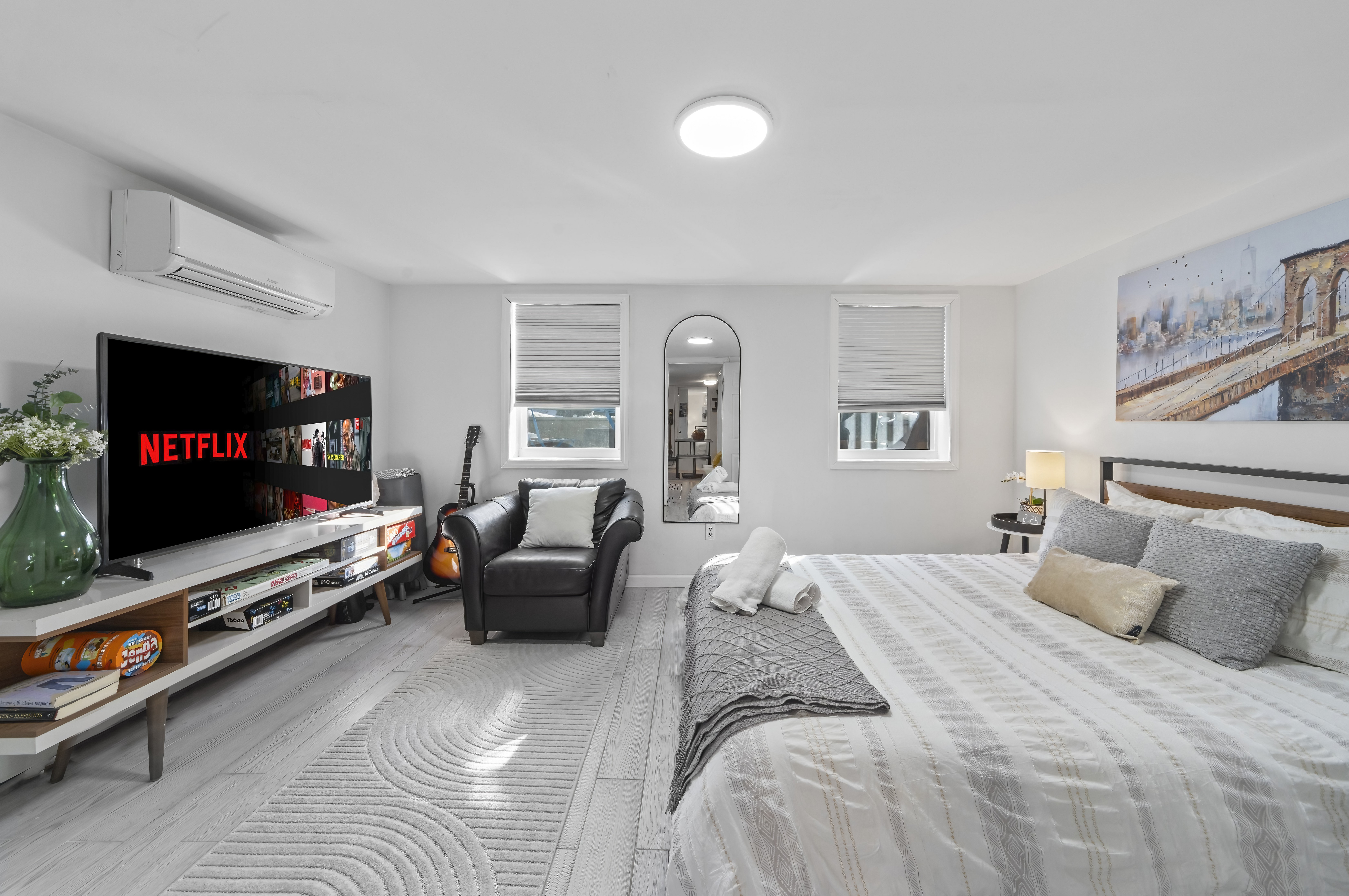 Primary bedroom with white platform bed and natural light